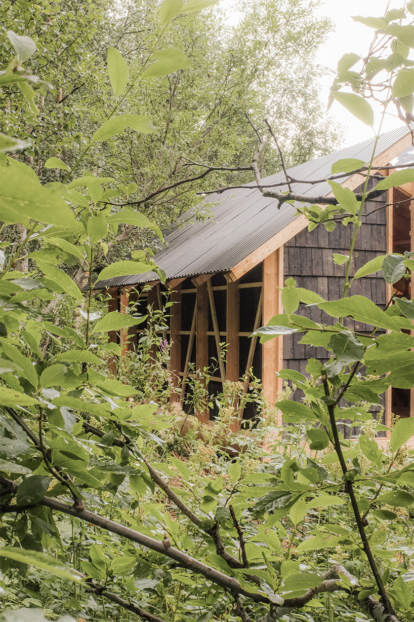 ma co builds glode fireplace shelter from reclaimed materials in northern norway 4