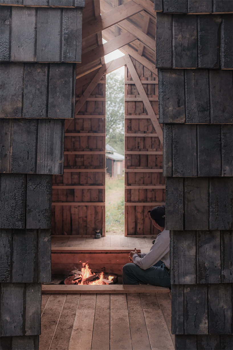 ma co builds glode fireplace shelter from reclaimed materials in northern norway 8