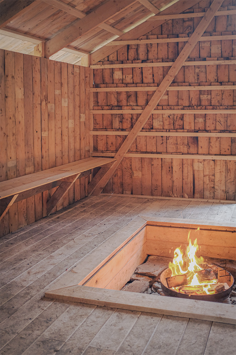 ma co builds glode fireplace shelter from reclaimed materials in northern norway 9