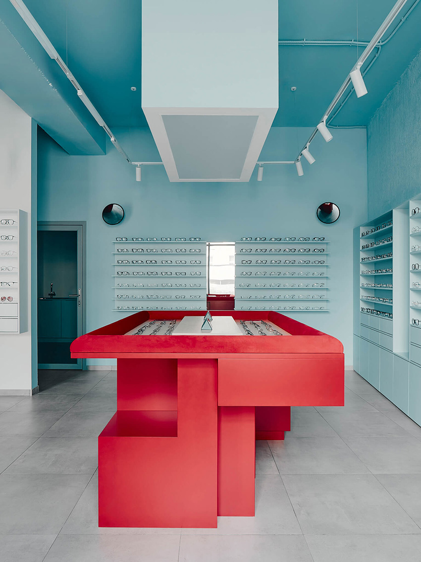 hubarch wraps an optics boutique in cold blue with single red interruption 12