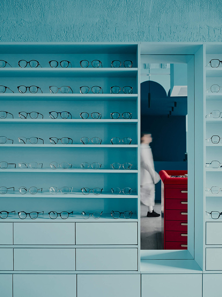 hubarch wraps an optics boutique in cold blue with single red interruption 5