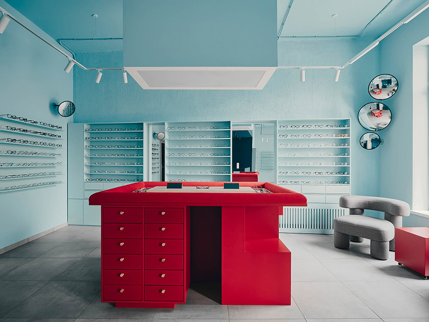 hubarch wraps an optics boutique in cold blue with single red interruption 8