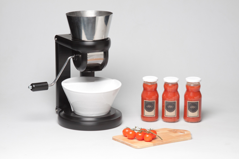 salsa maker squeezes tomatoes to produce traditional home-made sauce
