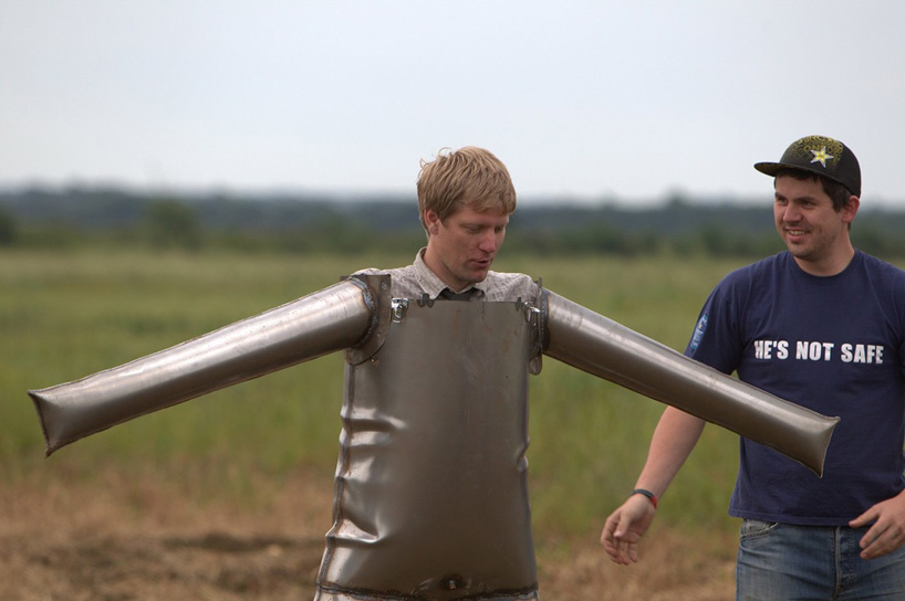 colin furze stands inside a fireworks display with self-built steel suit
