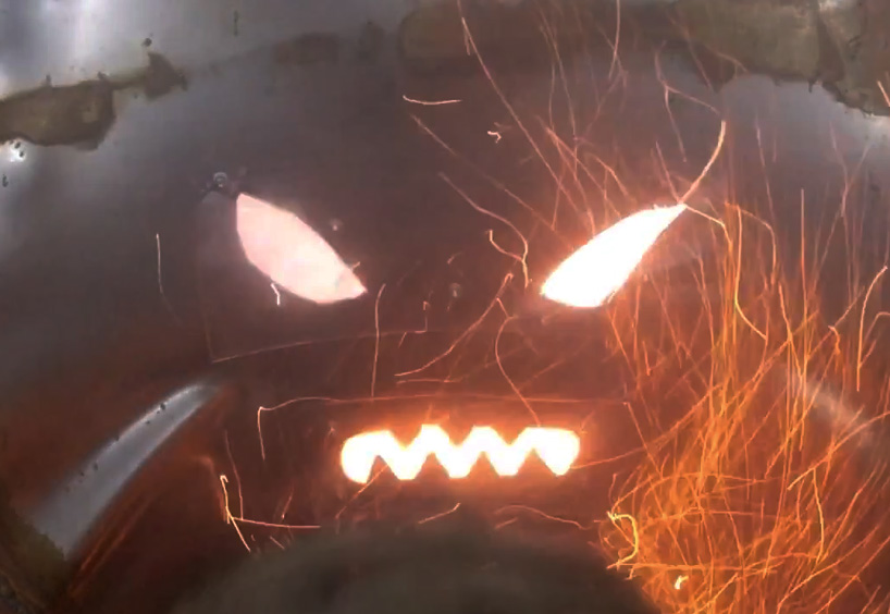 colin furze stands inside a fireworks display with self-built steel suit