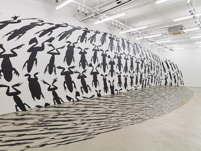 frogs funnel into the floor for regina silveira's amphibia installation