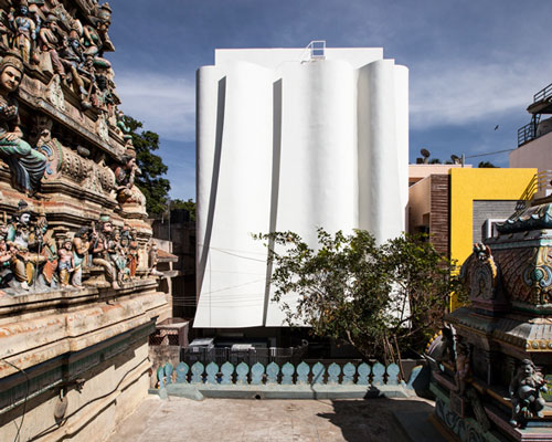 cadence's health clinic with folding façade sits adjacent to an ancient indian temple