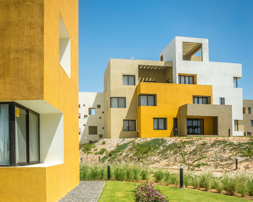 sanjay puri architects develops housing project in india as deconstructed yellow cubes