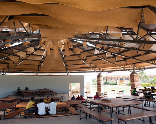 studio FH architects uses local materials to construct a school amphitheater in uganda