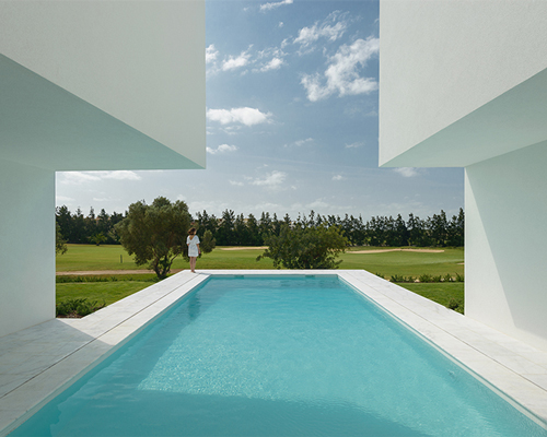 corpo atelier's secluded cubic residence basks under cobalt blue skies in portugal