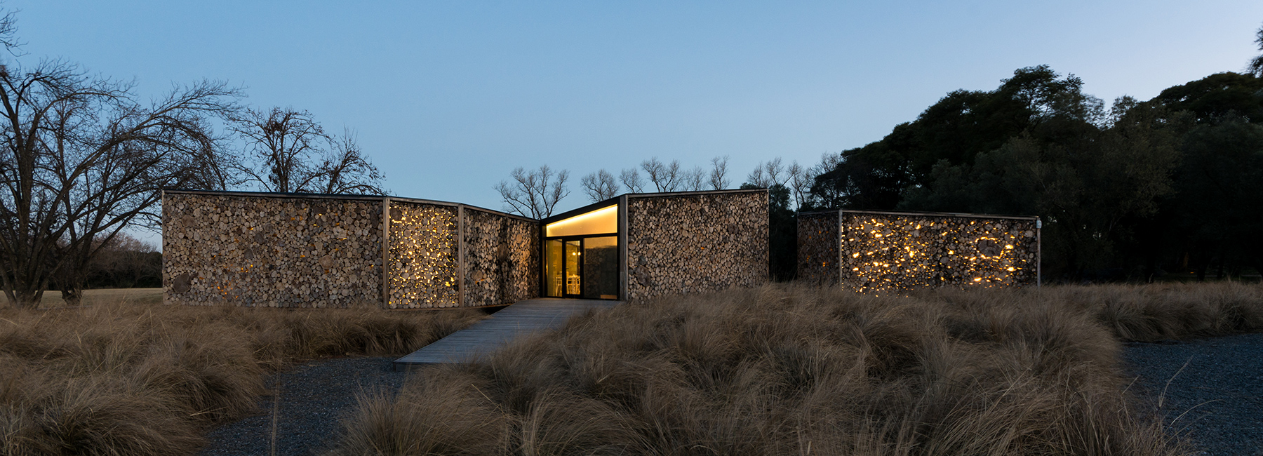 morini arquitectos filters light through a log façade for golf club in argentina