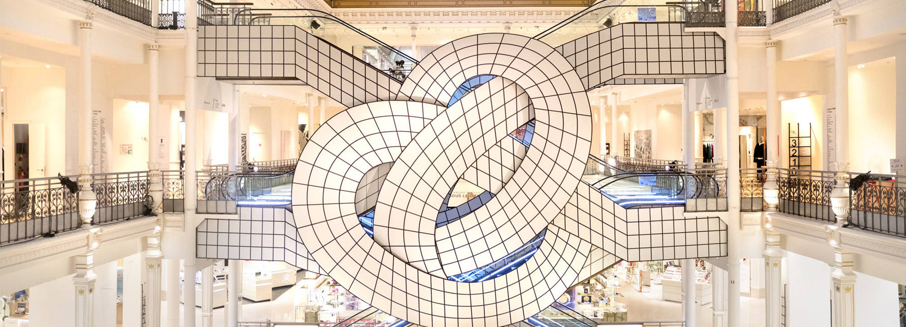 leandro erlich twists le bon marché's famed escalator into pretzel-like form