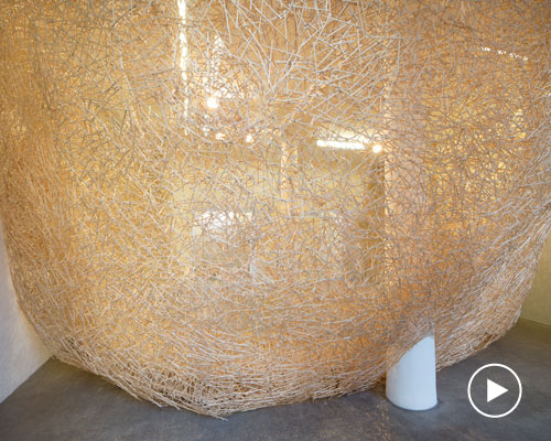 tadashi kawamata weaves 100,000 chopsticks into an immersive, parasitic 'nest'