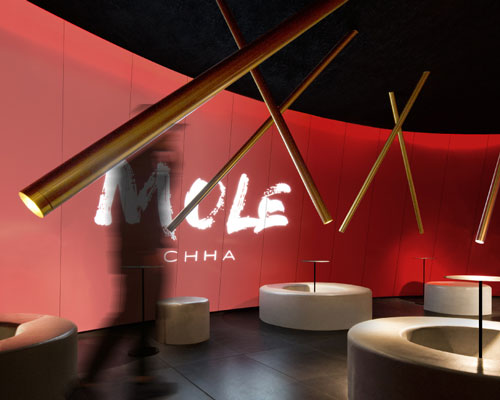 infinity nide's mole chha is a dome teahouse with red gradient walls and brass lighting tubes