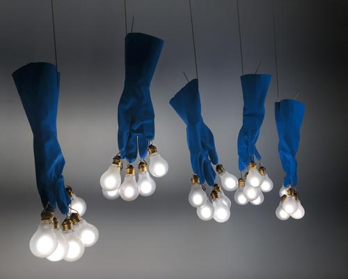 ingo maurer's luzy lights illuminate the fingertips of plastic gloves