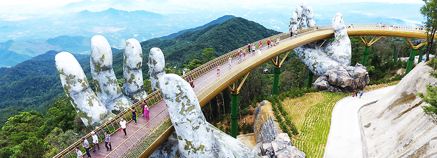 a giant pair of hands lift vietnam's da nang golden bridge into the sky