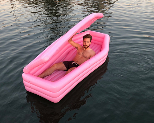 bury yourself this summer in this pink coffin pool float