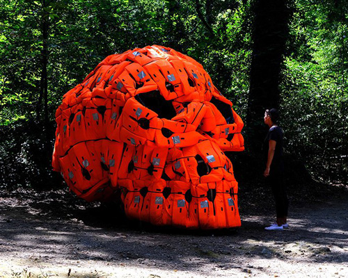pedro pires sculpts large-scale skull using 140 life vests and rubber from a refugee dinghy