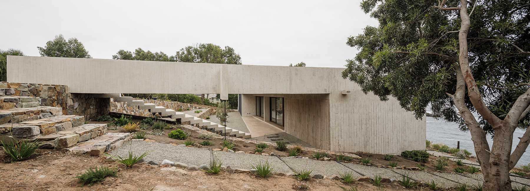 felipe assadi's concrete casa cipolla overlooks the rocky shoreline of a chilean lake