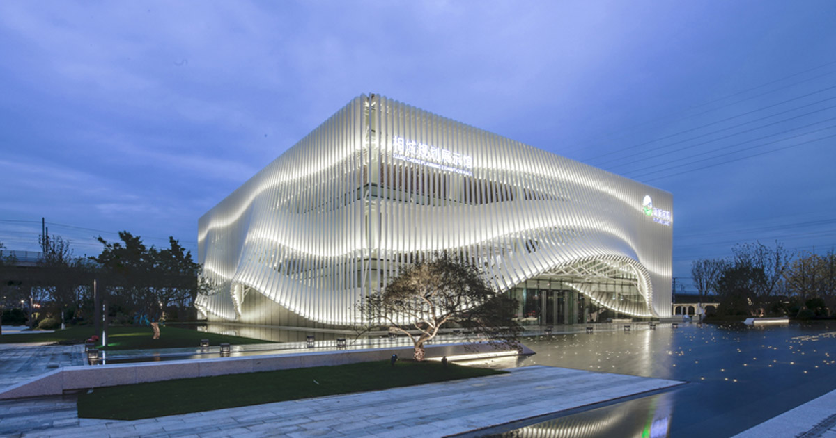 lacime architects cover exhibition hall with undulating façade in