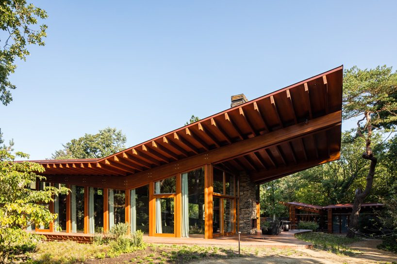 natrufied embeds cantilevered roof villa within the wooded surroundings of bergen