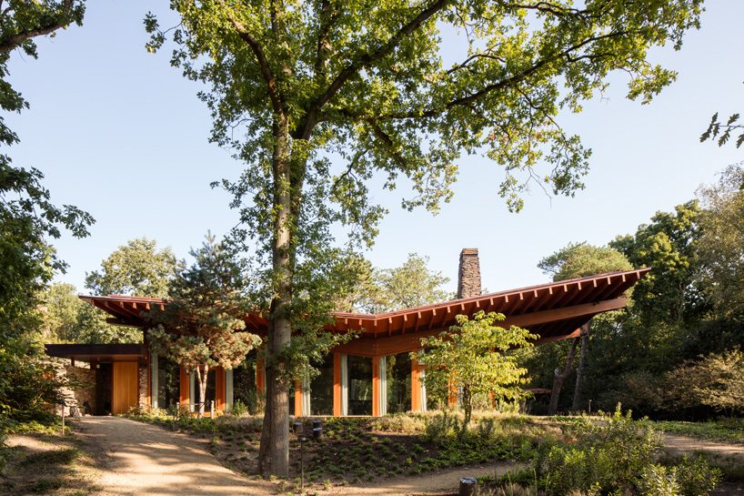 natrufied embeds cantilevered roof villa within the wooded surroundings of bergen