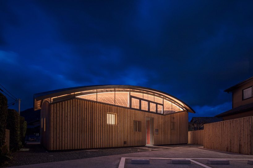curved wood lattice roof hangs above nasca's blue sky nursery school in japan - 16