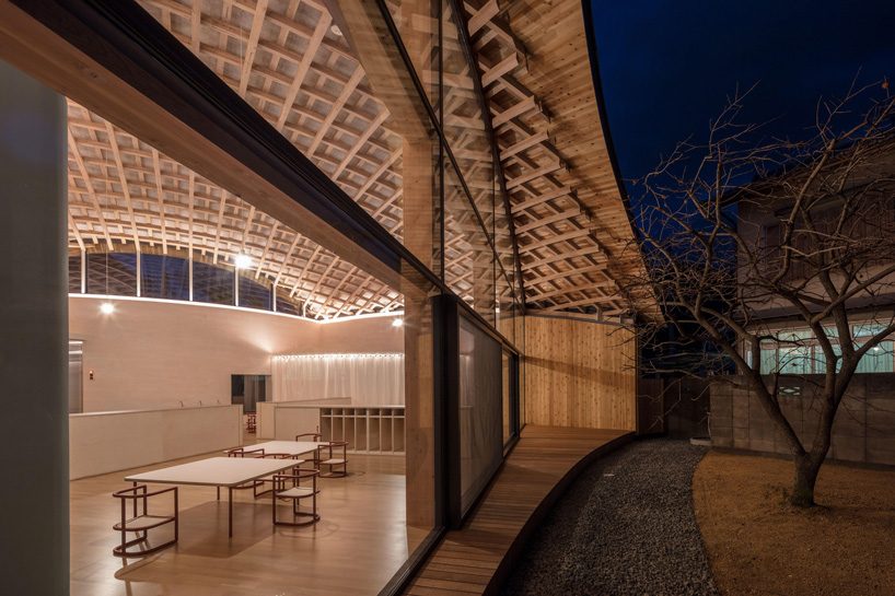 curved wood lattice roof hangs above nasca's blue sky nursery school in japan - 15