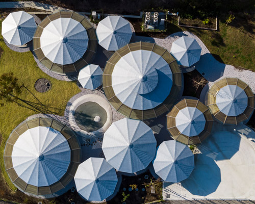 tezuka architects forms an array of round timber structures for 'muku nursery' in japan