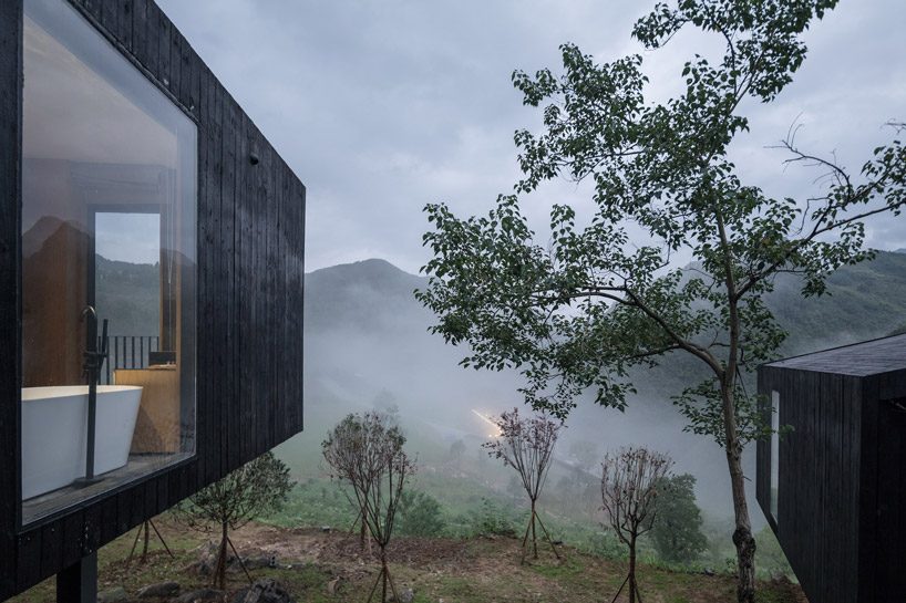 ZJJZ builds charred timber volumes on a hillside in rural china for 'woodhouse hotel' designboom