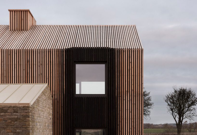  bureau de change combines interlocking barn volumes for house in rural england