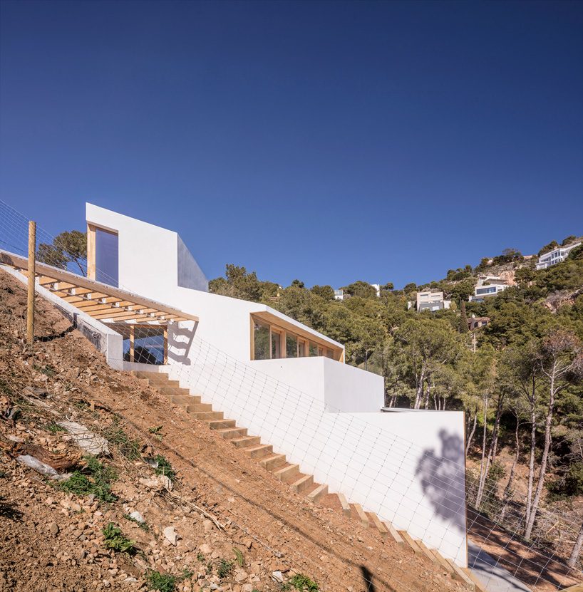 05 AM arquitectura's mediterranean house cascades down a steep slope in tamariu, spain