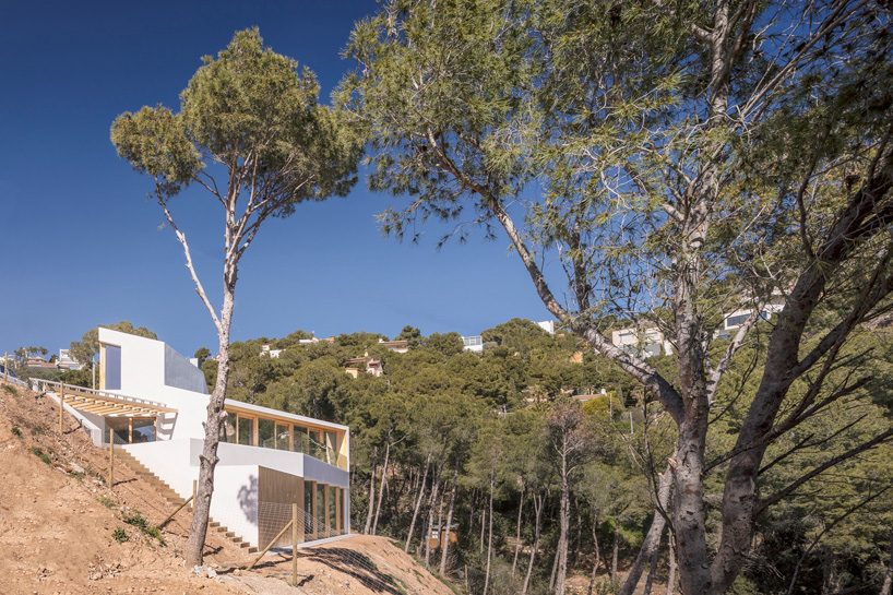 05 AM arquitectura's mediterranean house cascades down a steep slope in tamariu, spain