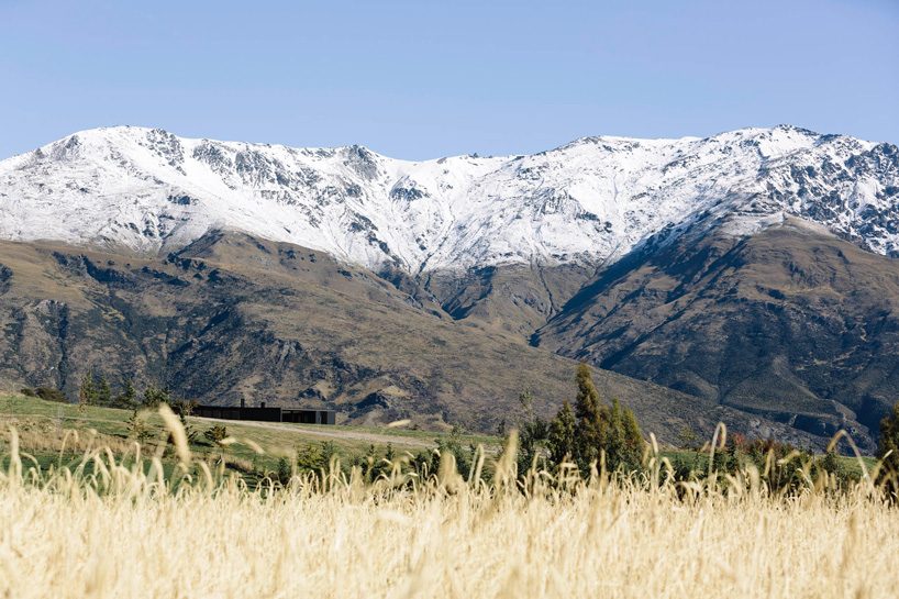 fearon hay architects builds house in new zealand's alps as cluster of blackened volumes