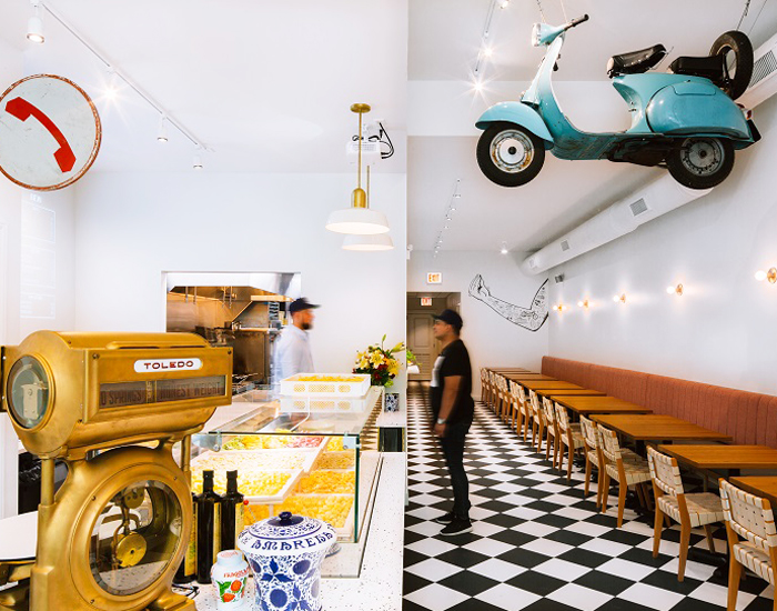 the space is decorated with terrazzo, brass finishes, red garland