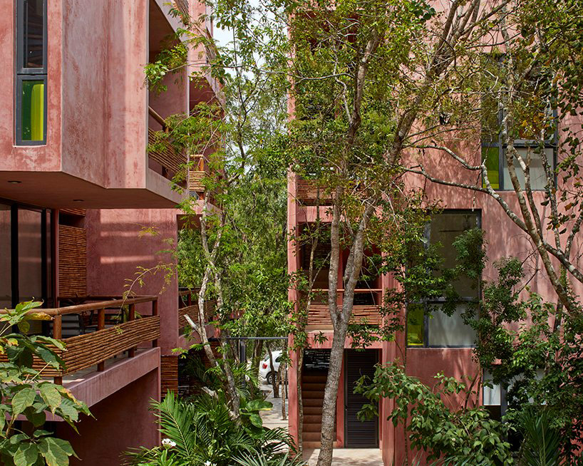 residential complex in mexico colored pink to contrast its lush green surroundings
