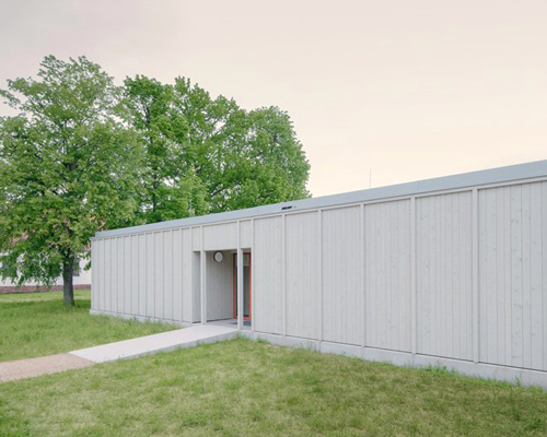 gray finished larch timber clads ko/ok architektur's new sports venue in germany
