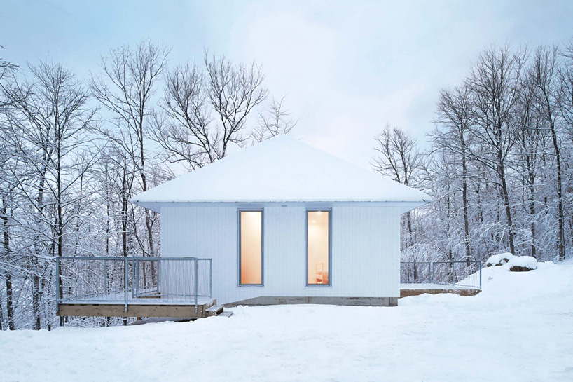 naturehumaine sets monochrome 'poisson blanc' cabin within forest in canada