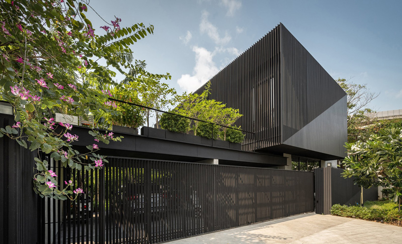 octane's k krit residence in bangkok is clad in façade of black unequal steel battens