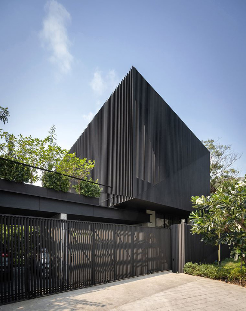 octane's k krit residence in bangkok is clad in façade of black unequal steel battens