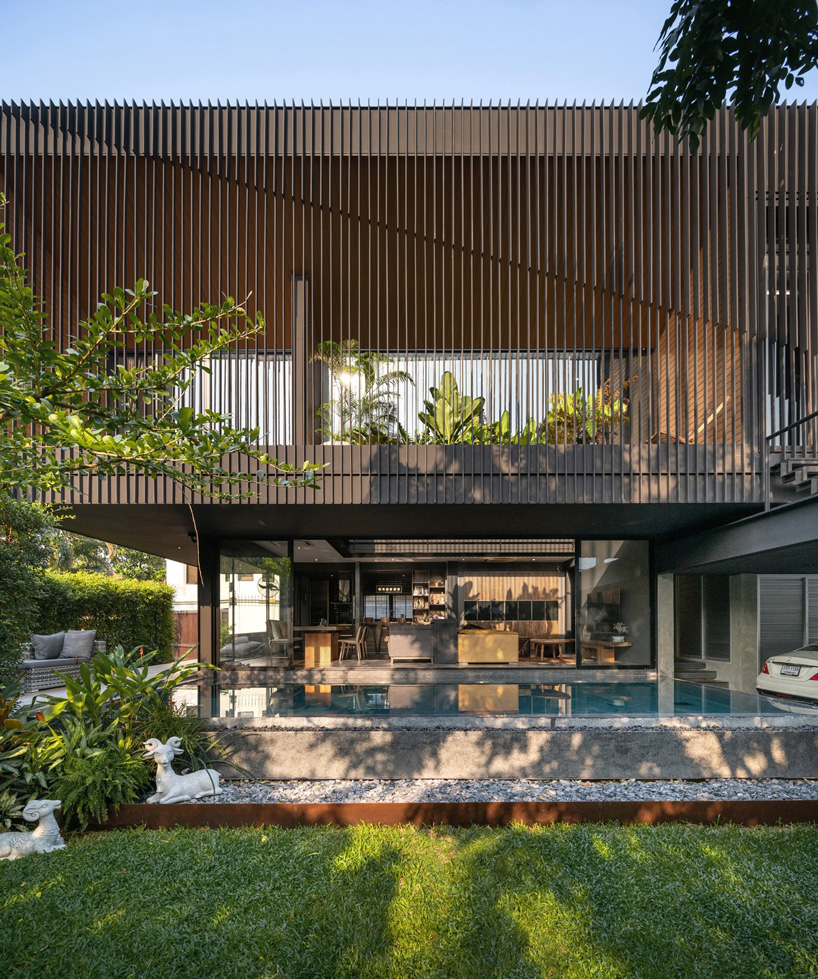 octane's k krit residence in bangkok is clad in façade of black unequal steel battens