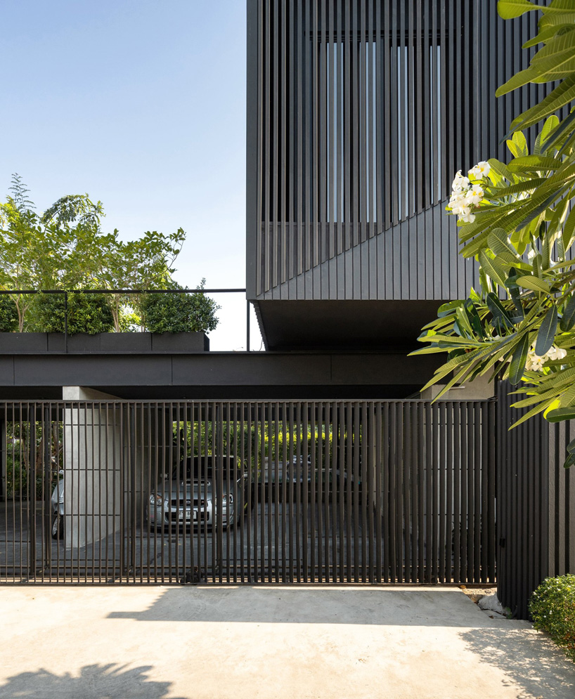 octane's k krit residence in bangkok is clad in façade of black unequal steel battens
