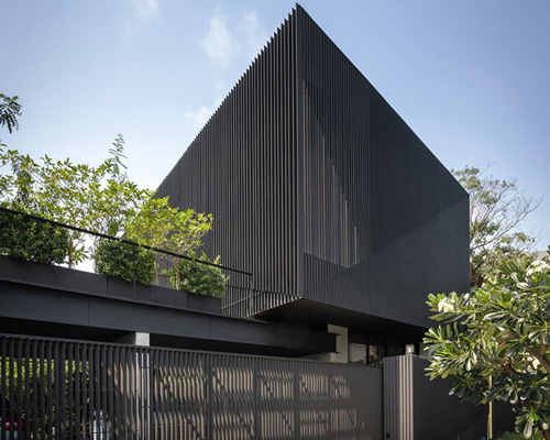 octane's k krit residence in bangkok is clad in façade of black unequal steel battens