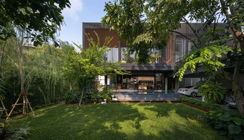 octane's k krit residence in bangkok is clad in façade of black unequal steel battens