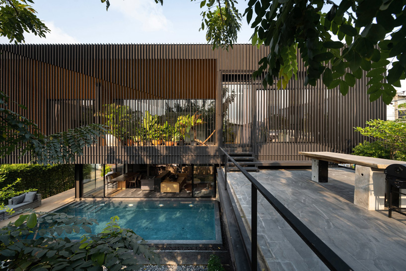octane's k krit residence in bangkok is clad in façade of black unequal steel battens