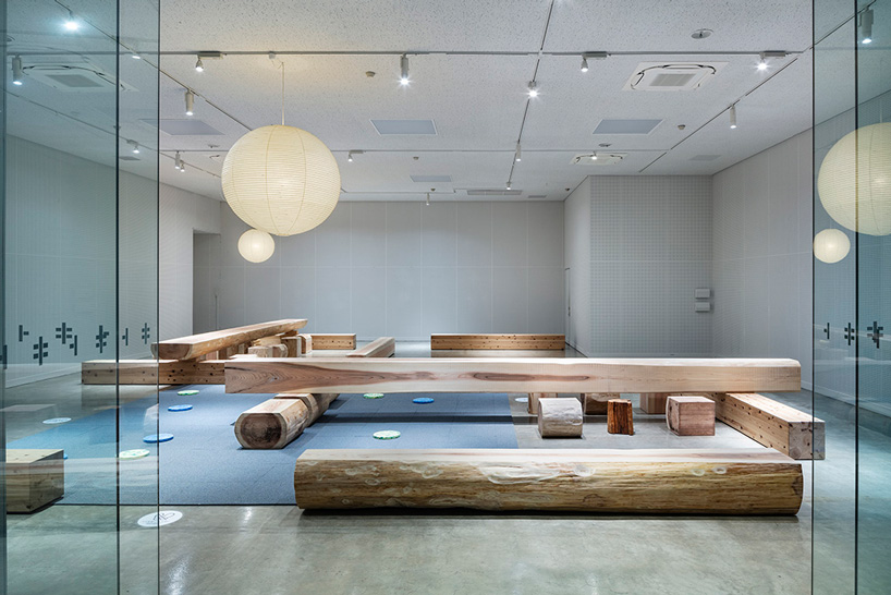 torafu architects renovates museum gallery with cedar logs as benches and tables in japan