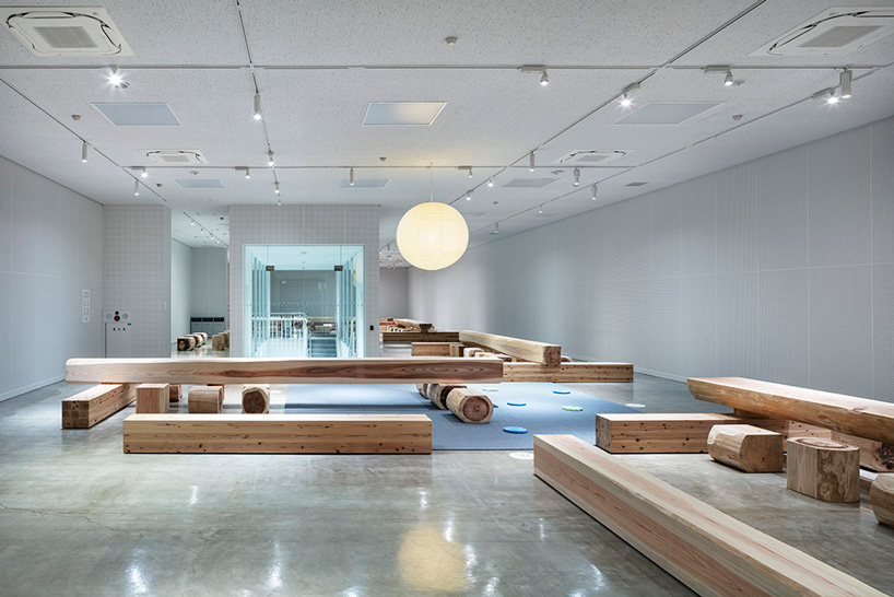 torafu architects renovates museum gallery with cedar logs as benches and tables in japan