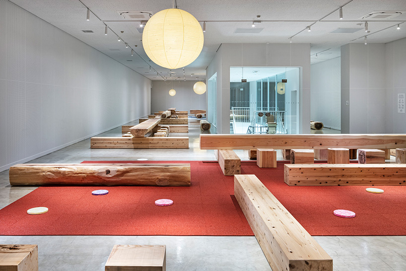 torafu architects renovates museum gallery with cedar logs as benches and tables in japan