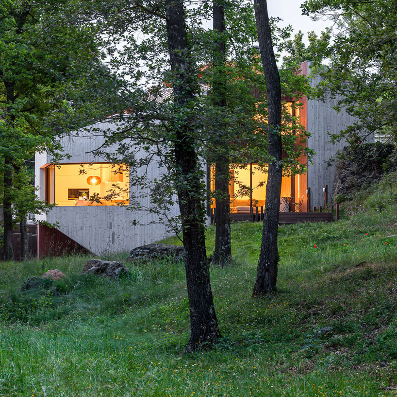 arnau estudi d'arquitectura embeds the 'forest stone' house into a sloped site in spain designboom