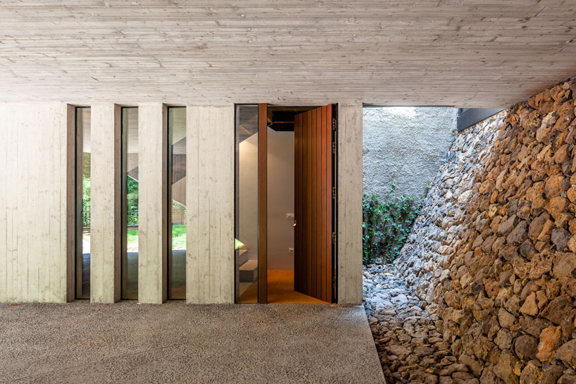arnau estudi d'arquitectura embeds the 'forest stone' house into a sloped site in spain designboom